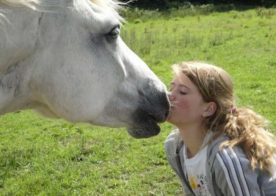 Girl kissing horse on Dartmoor