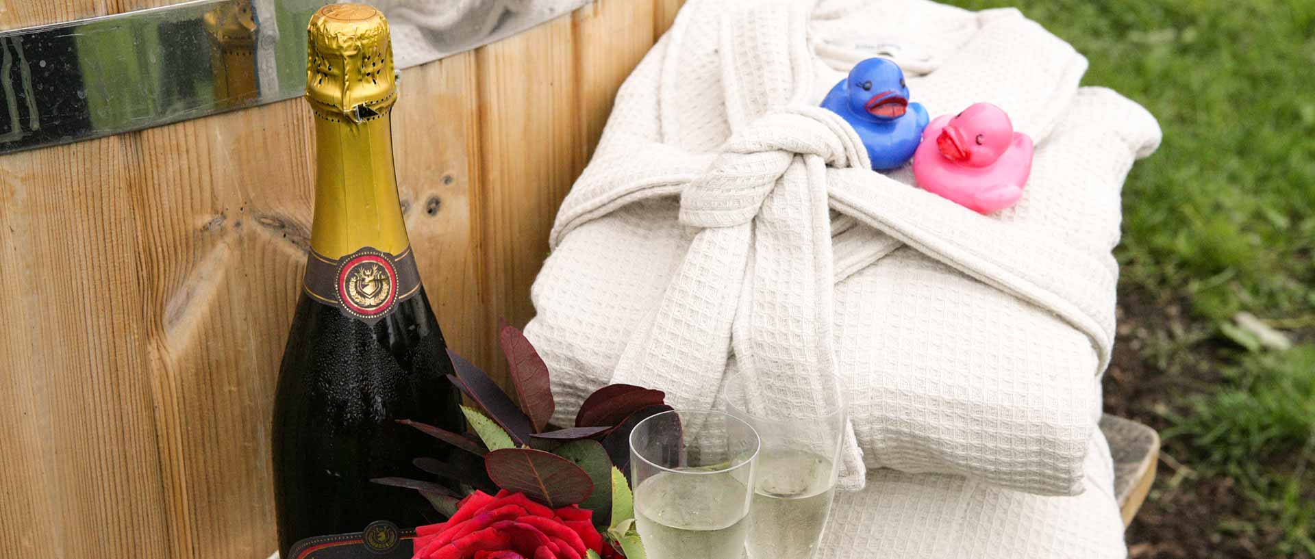 Hot tub with prosecco, roses, glasses and bathrobes,
