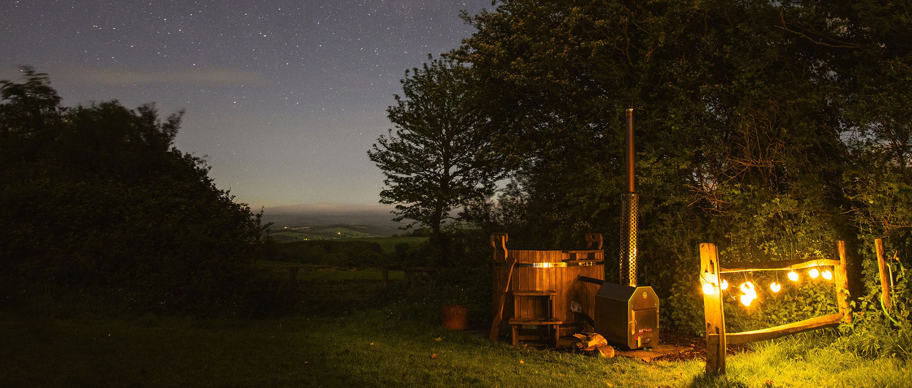 Borough Farm at night with candles, log fire and pizza oven